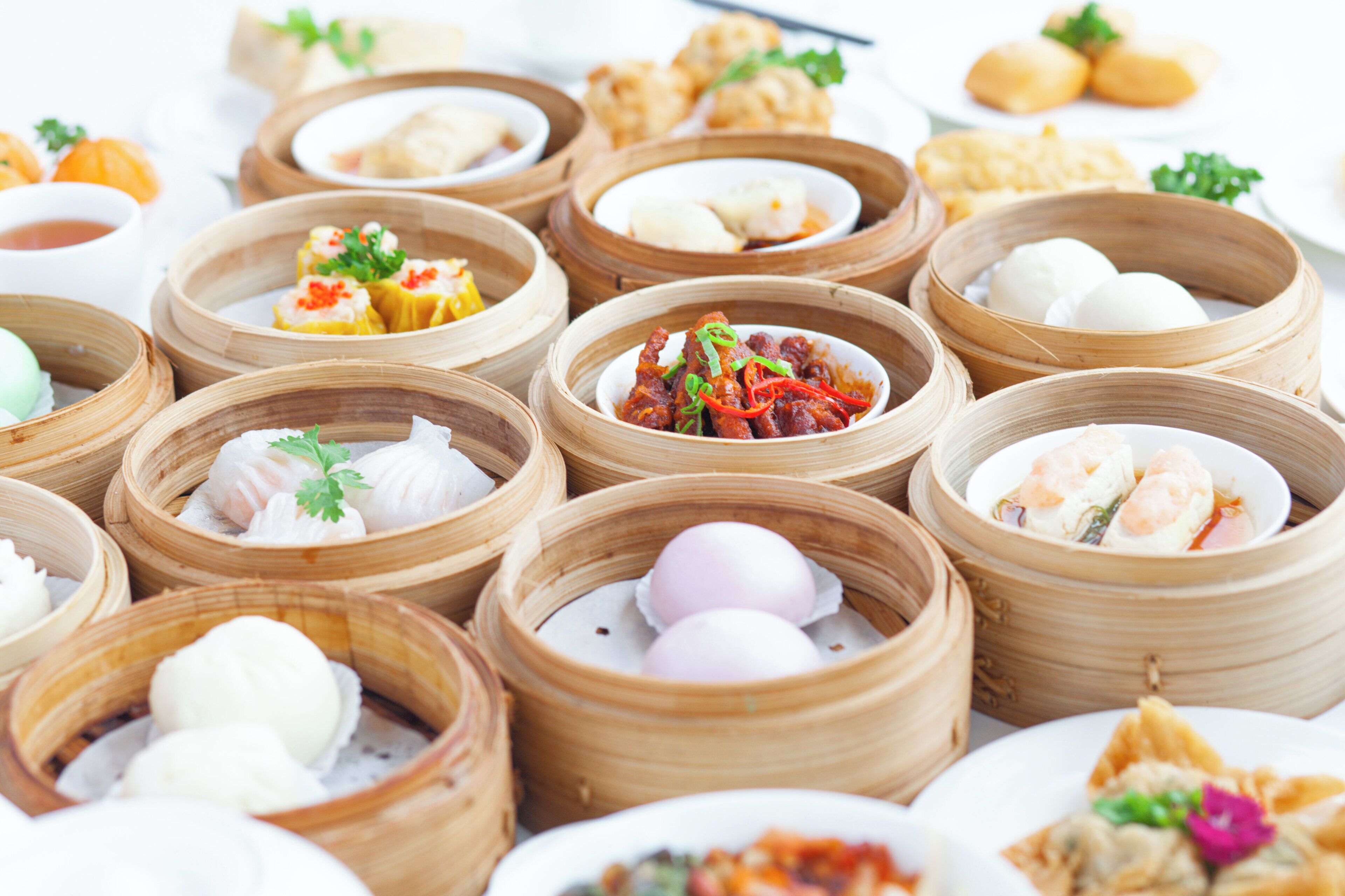 Une variété de plats de dim sum servis dans des paniers à vapeur en bambou.