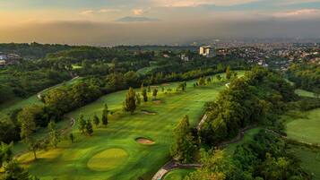 A golf course with a view of a cityscape in the background.
