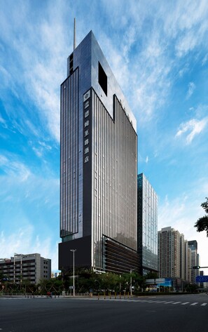A modern high-rise building with a prominent vertical design and reflective glass facade. - Wyndham Grand Shenzhen (Shenzhen)