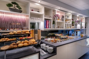 Um buffet com diversos pratos e disposição organizada.