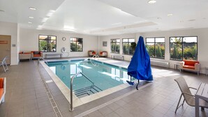 An indoor swimming pool with clear water, surrounded by lounge chairs and a covered seating area. - Hampton Inn Butler (Butler)