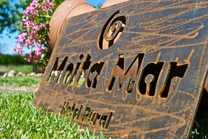 A metal sign with the text "Maith Ma" and "Hotel Rural" engraved on it.