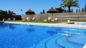 Piscine extérieure, parasols de plage, chaises longues