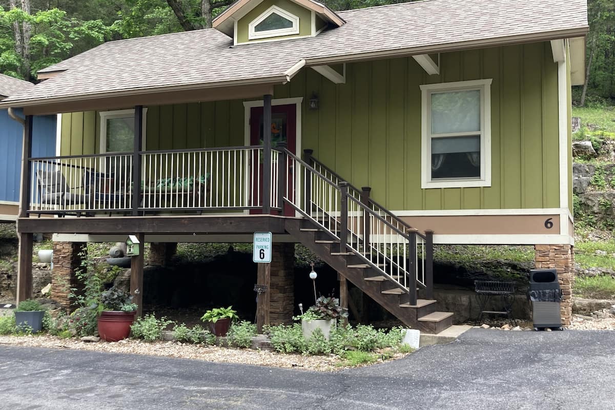 A two-story house with a balcony, a staircase, and a 'Reserved Parking 6' sign.