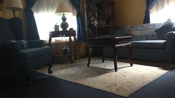 A living room with a sofa, a table, a lamp, and a cabinet.