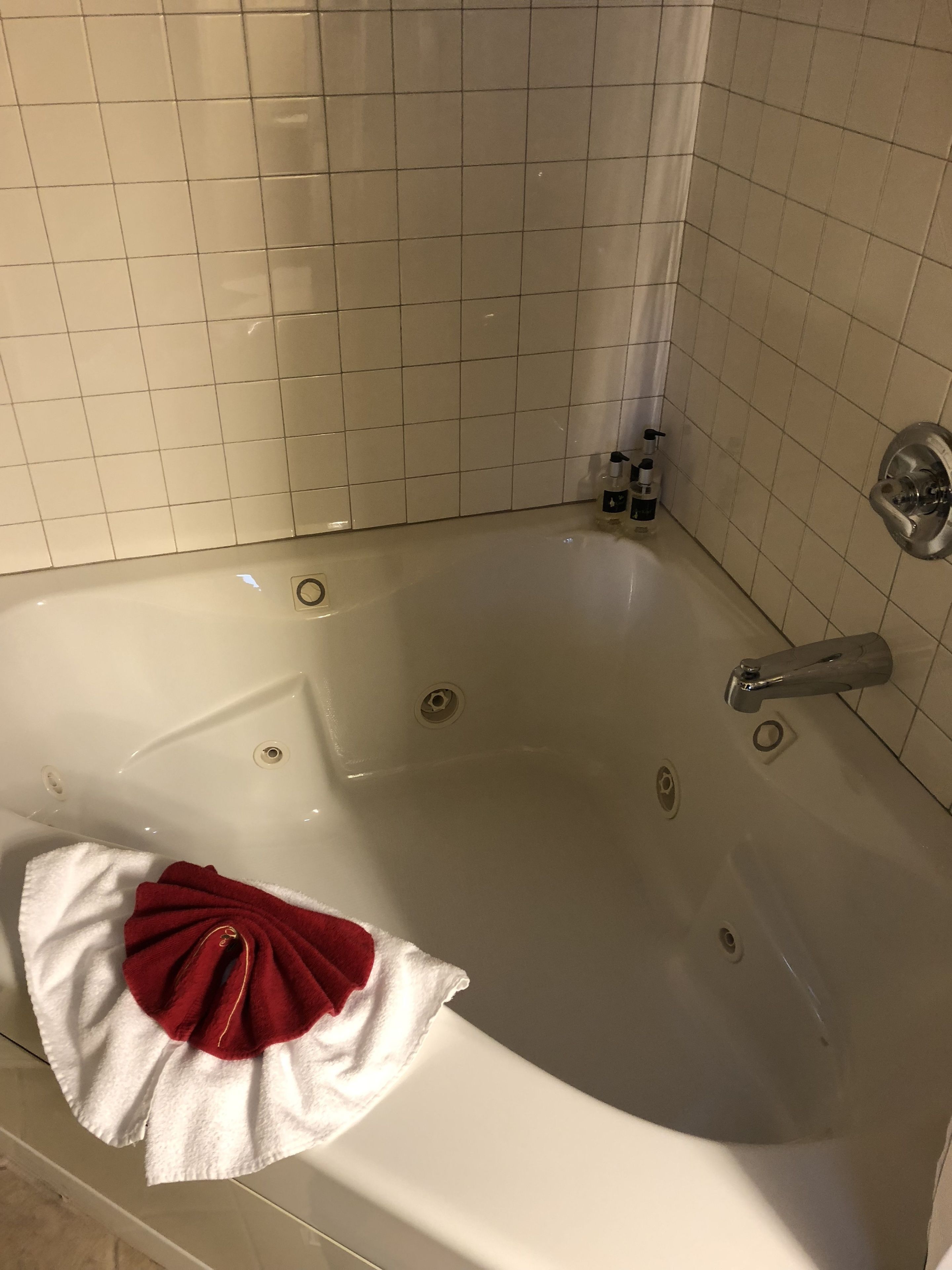 Une baignoire avec une serviette blanche et une serviette rouge.