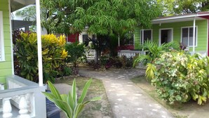 Una casa verde con un camino empedrado que lleva a la entrada.