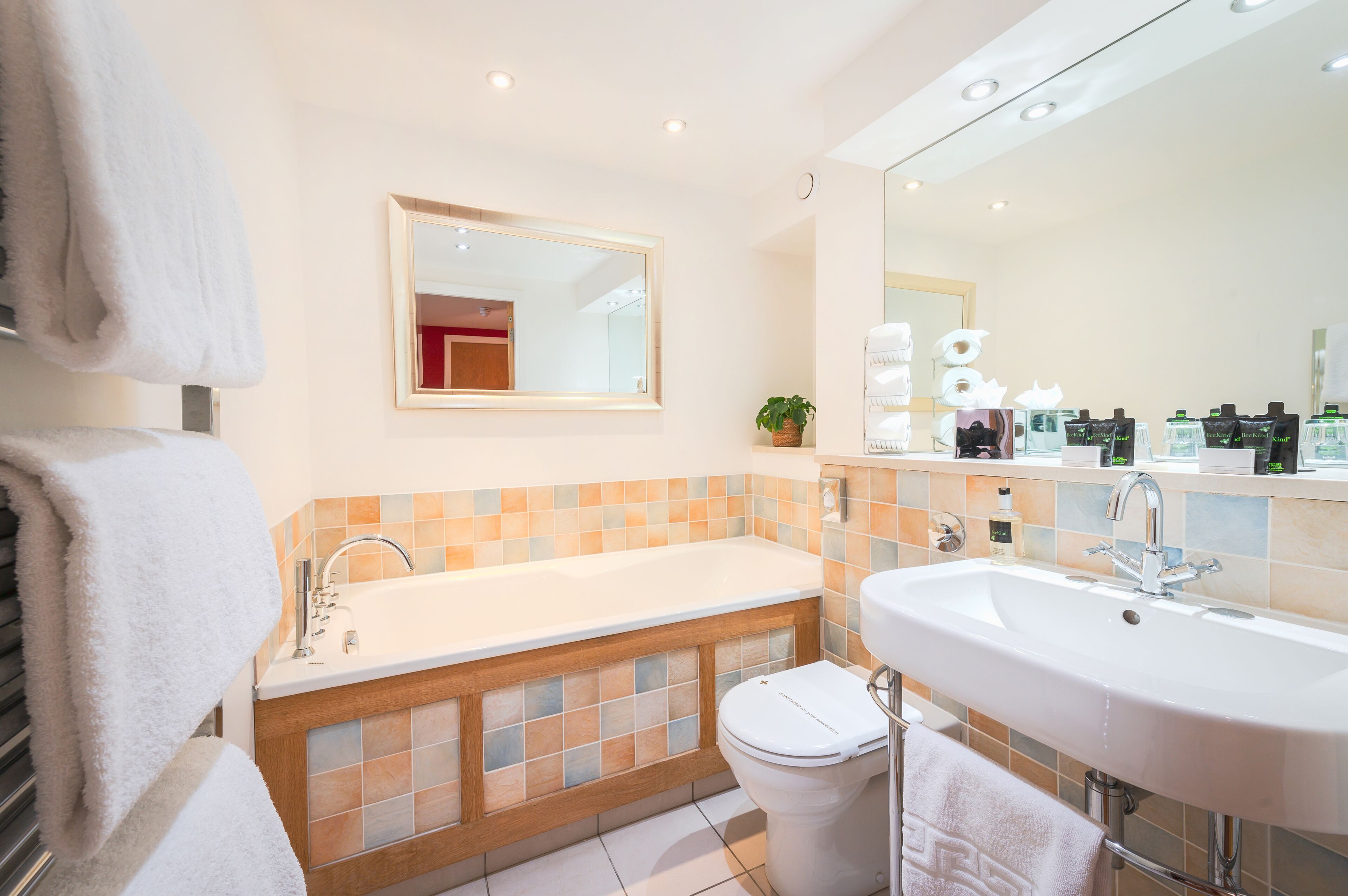 Een moderne badkamer met een bad, een wastafel en een toilet.