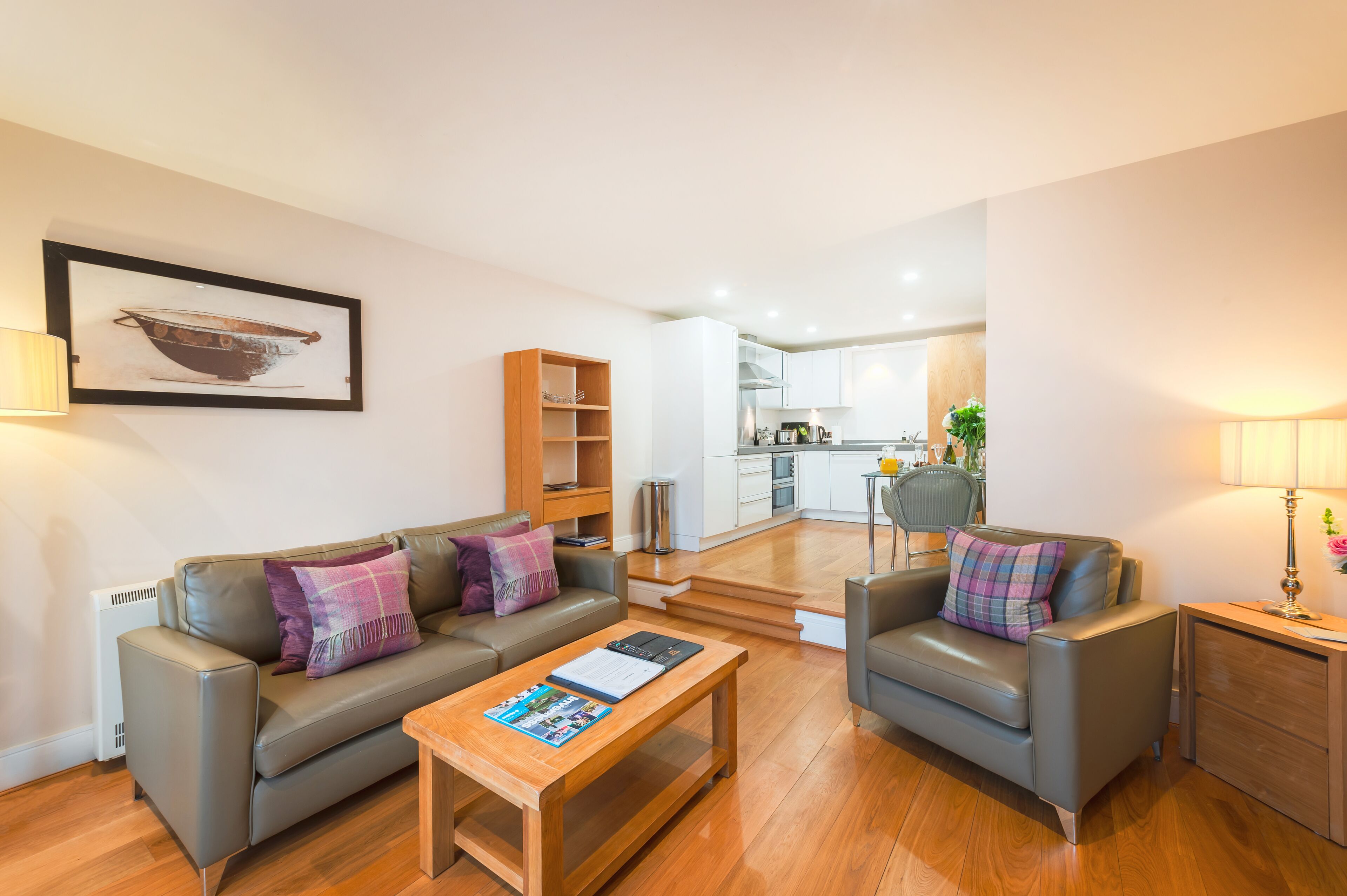 A modern living room with a sofa, coffee table, and a framed picture on the wall.