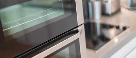 Una cocina moderna con electrodomésticos de acero inoxidable, incluyendo un horno y una estufa.