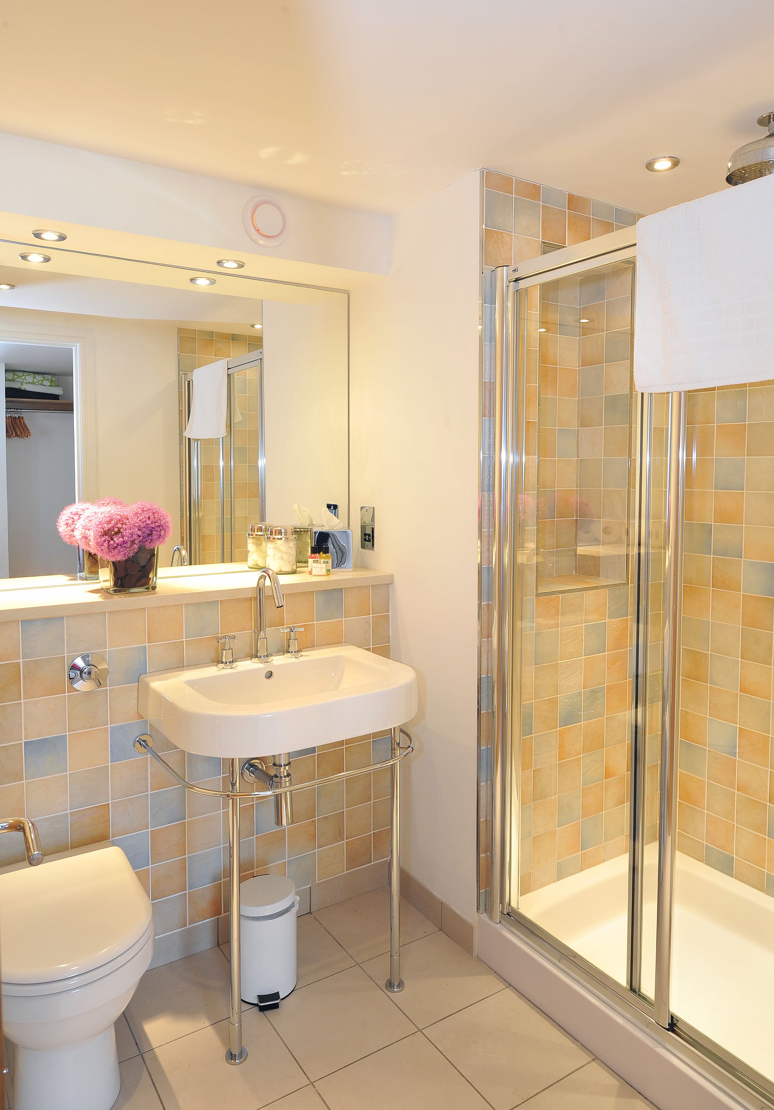 Une salle de bain moderne avec une douche à parois de verre, un lavabo blanc et des toilettes.