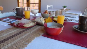 A breakfast table with various food items, drinks, and utensils. - Pat'ta Hoiri Hotel (San Pedro de Atacama)