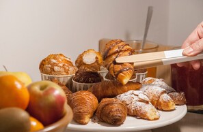 A plate of assorted pastries and fruits. - Casa Mathilda (Barcelona)