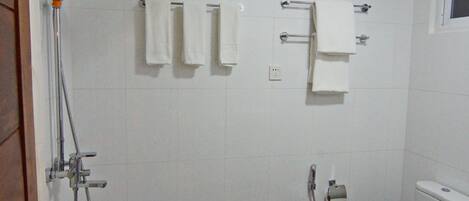 A bathroom with a shower, toilet, and sink.