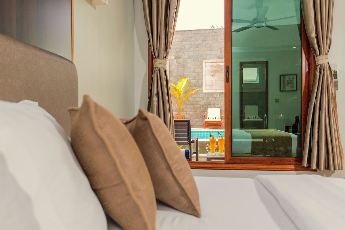 Une chambre d’hôtel avec un lit, une vue sur la piscine et une porte-fenêtre coulissante.