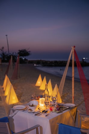 A table set for dinner on a beach with a view of the sea. - Kaani Village & Spa (Maafushi)