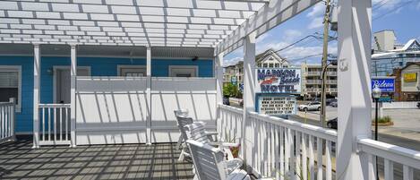 A covered outdoor area with white railings and a wooden deck.
