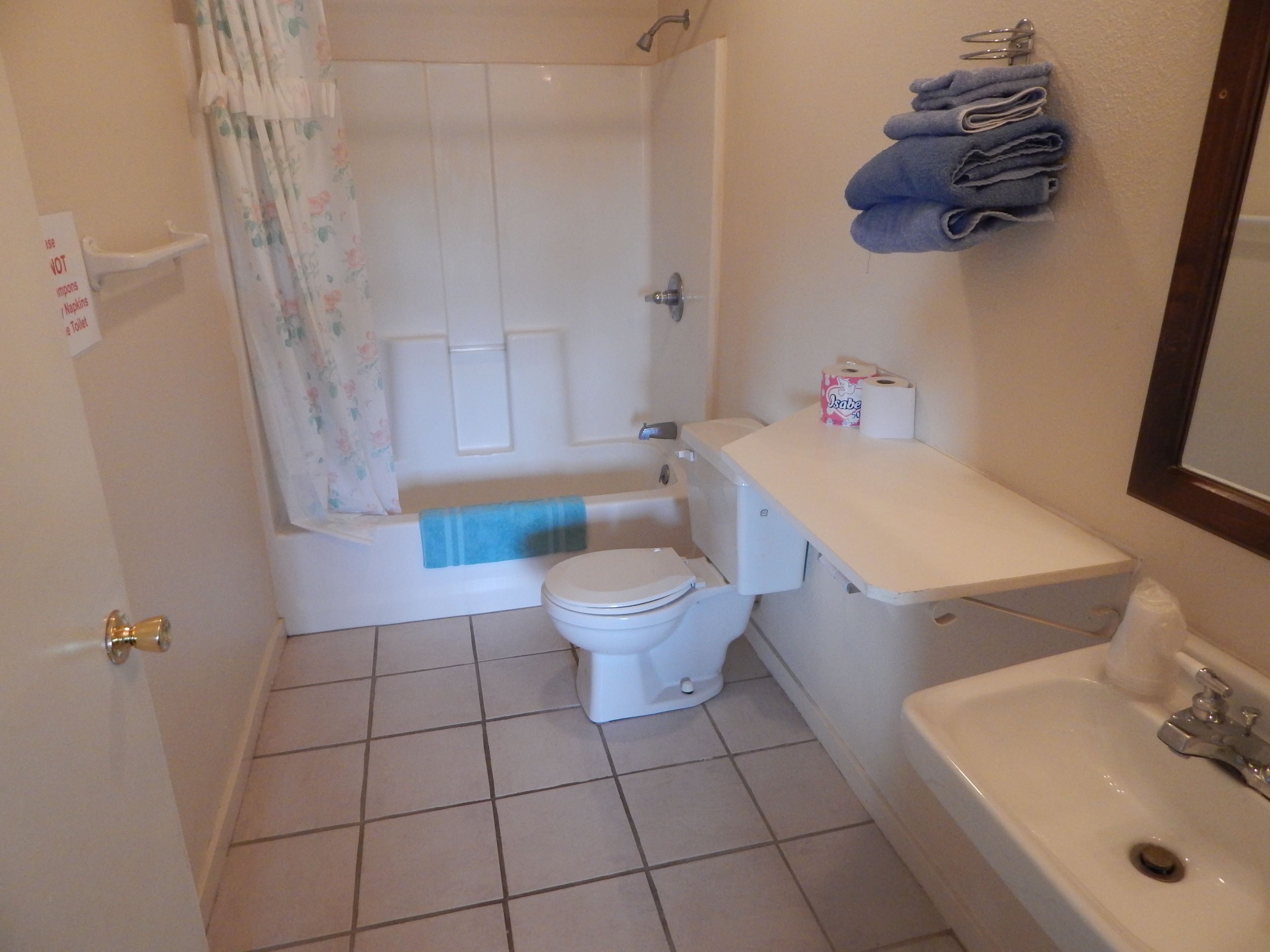 A bathroom with a toilet, sink, and bathtub.