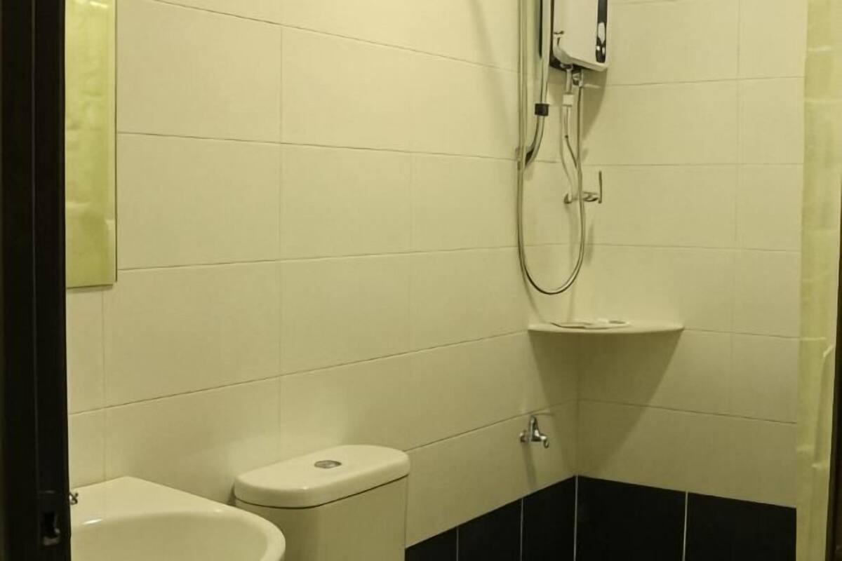 A bathroom with a toilet, bidet, and a shower.