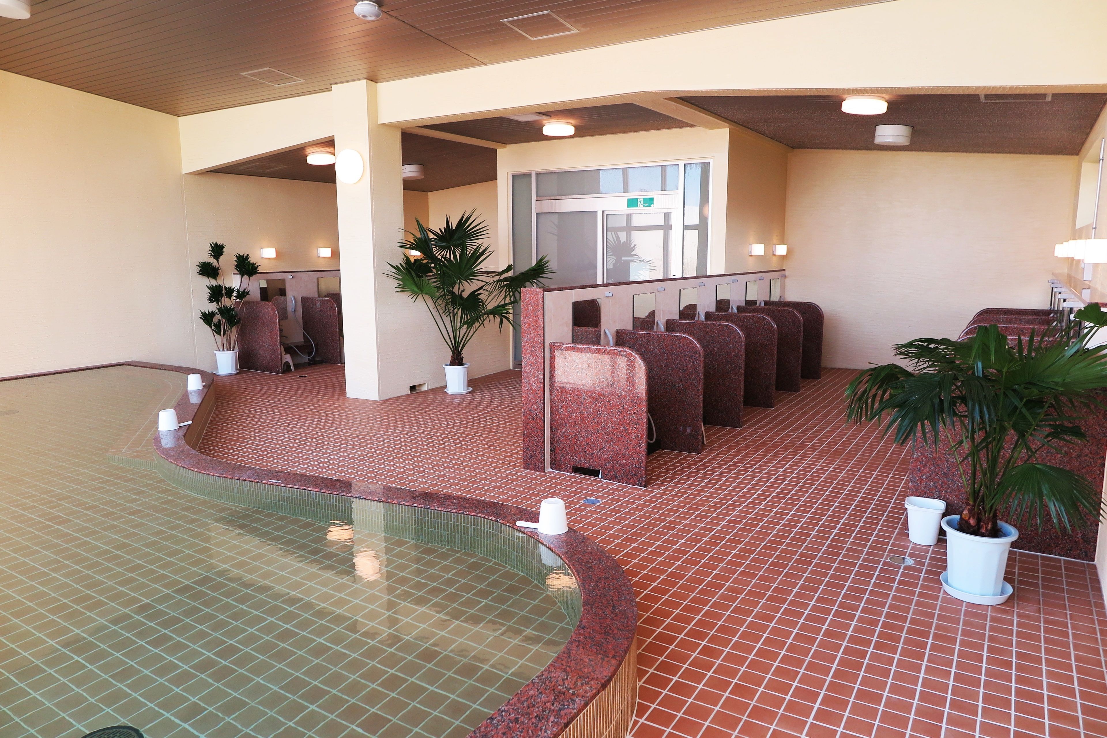 A pool area with seating and potted plants.
