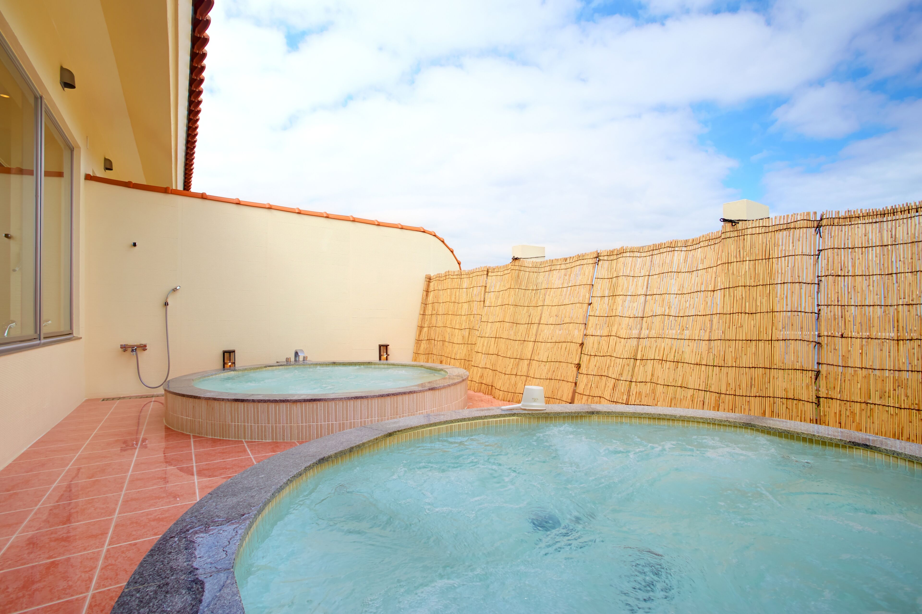 Un espace bien-être comprenant deux bains à remous et un sol carrelé.