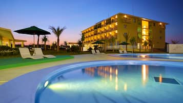 Relax by the pool surrounded by lounge chairs and umbrellas.