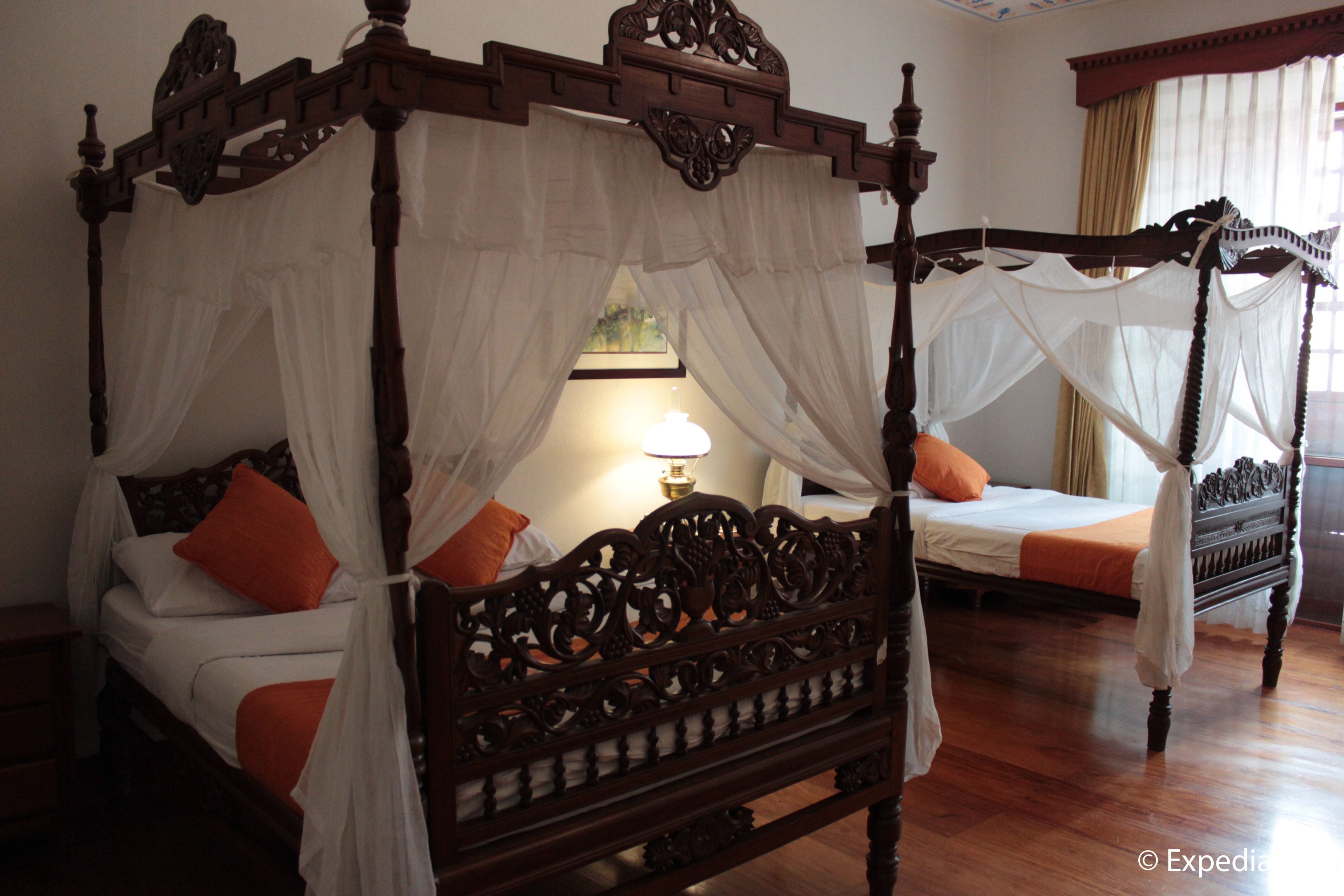 A four-poster bed with a canopy, two pillows, and a bedside table.