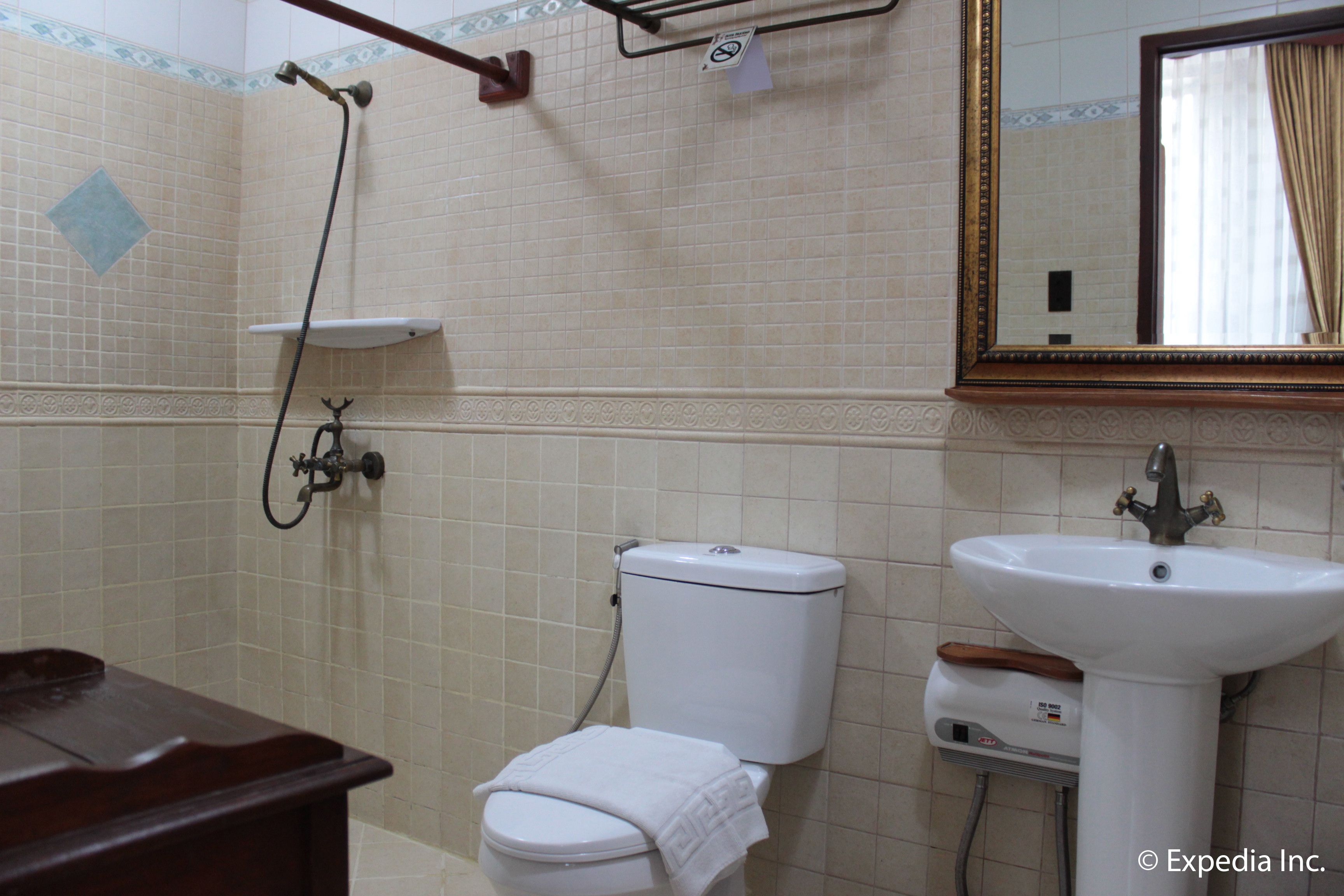 Une salle de bain équipée de toilettes, d’un lavabo et d’une douche.