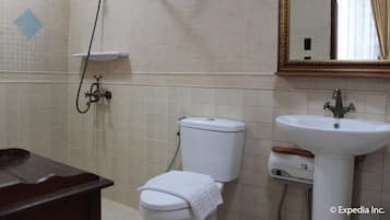 Une salle de bain équipée de toilettes, d’un lavabo et d’une douche.