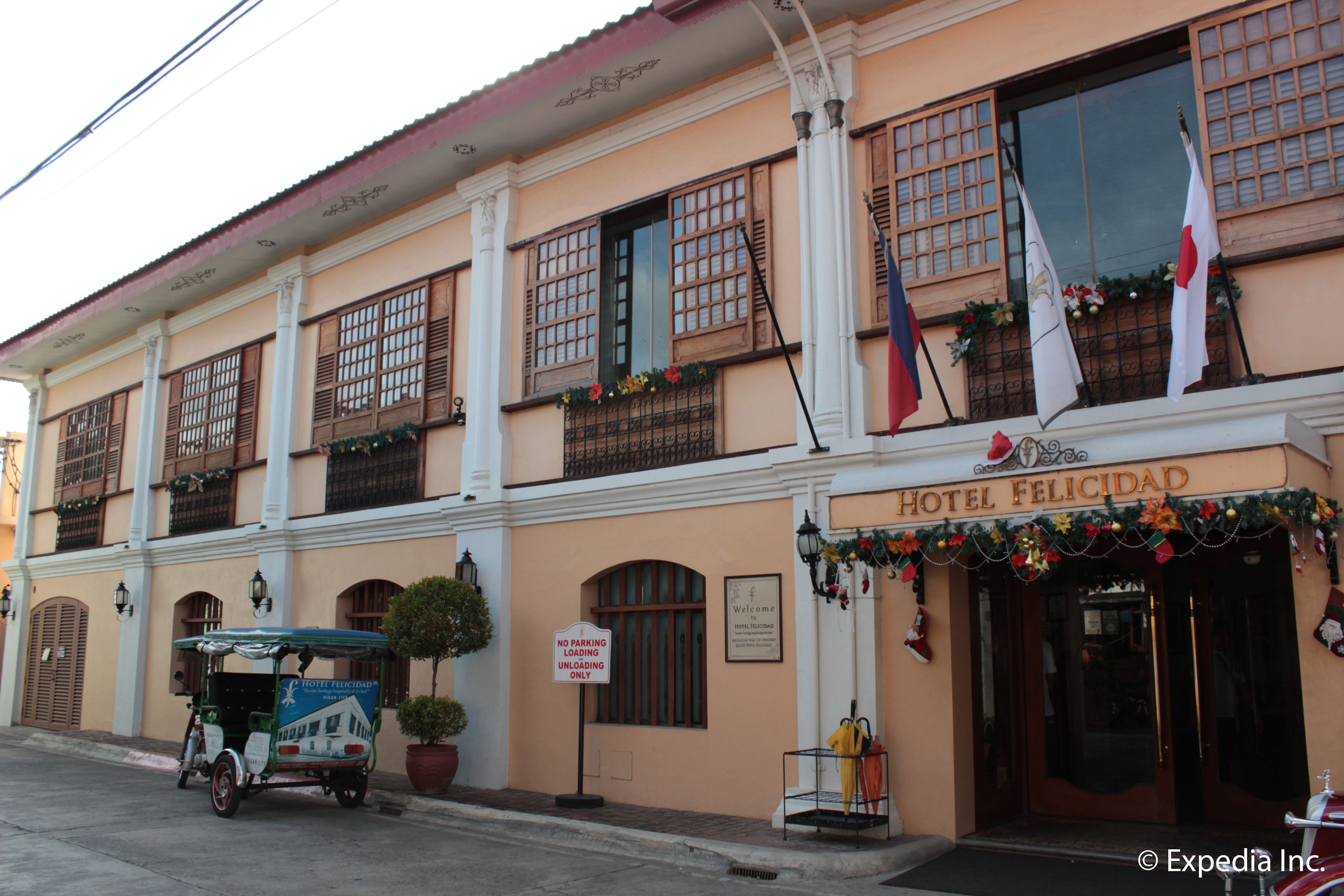 A building with a sign reading "Hotel Felicidad" and a "No Parking" sign.