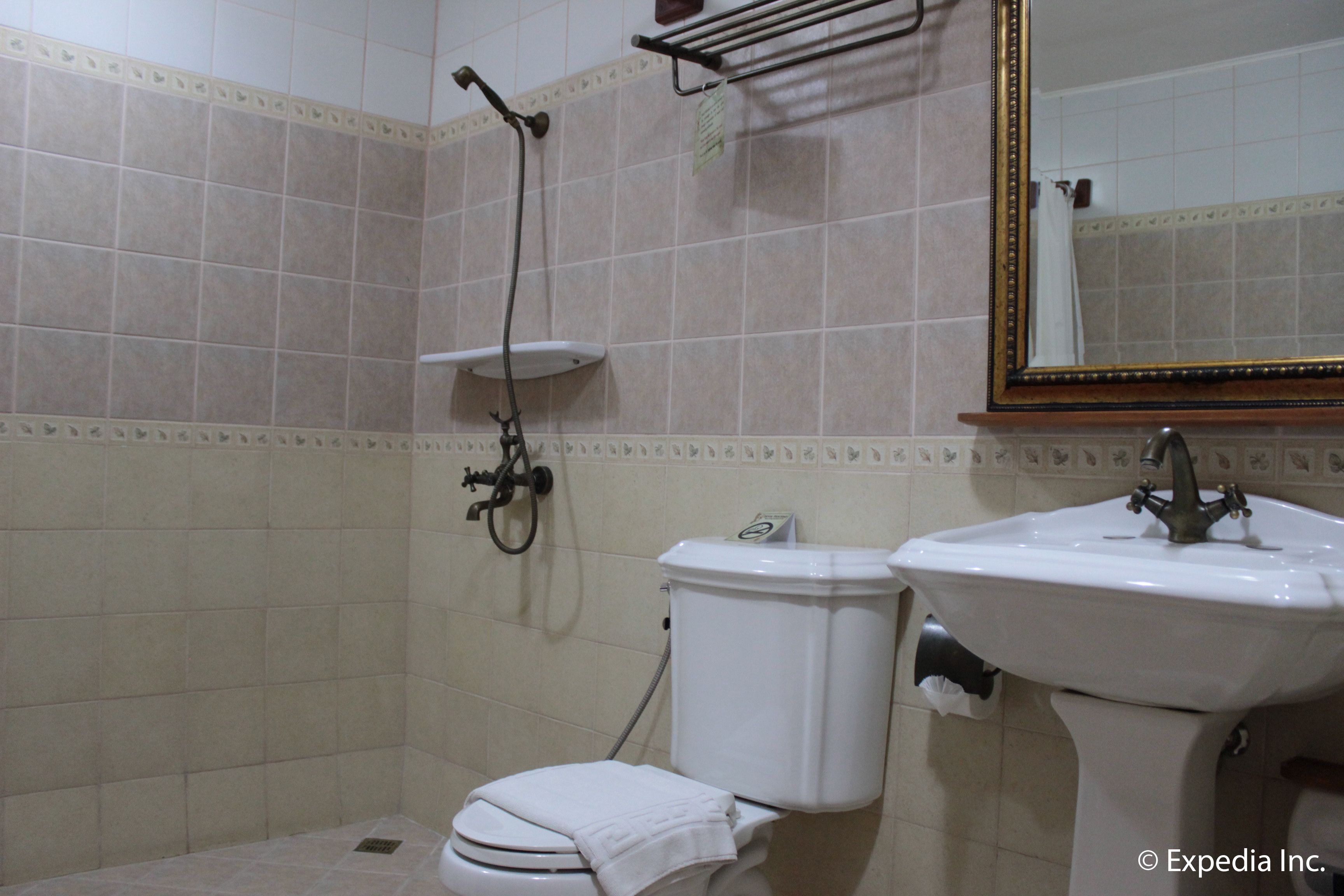 A bathroom with a toilet, sink, and shower.