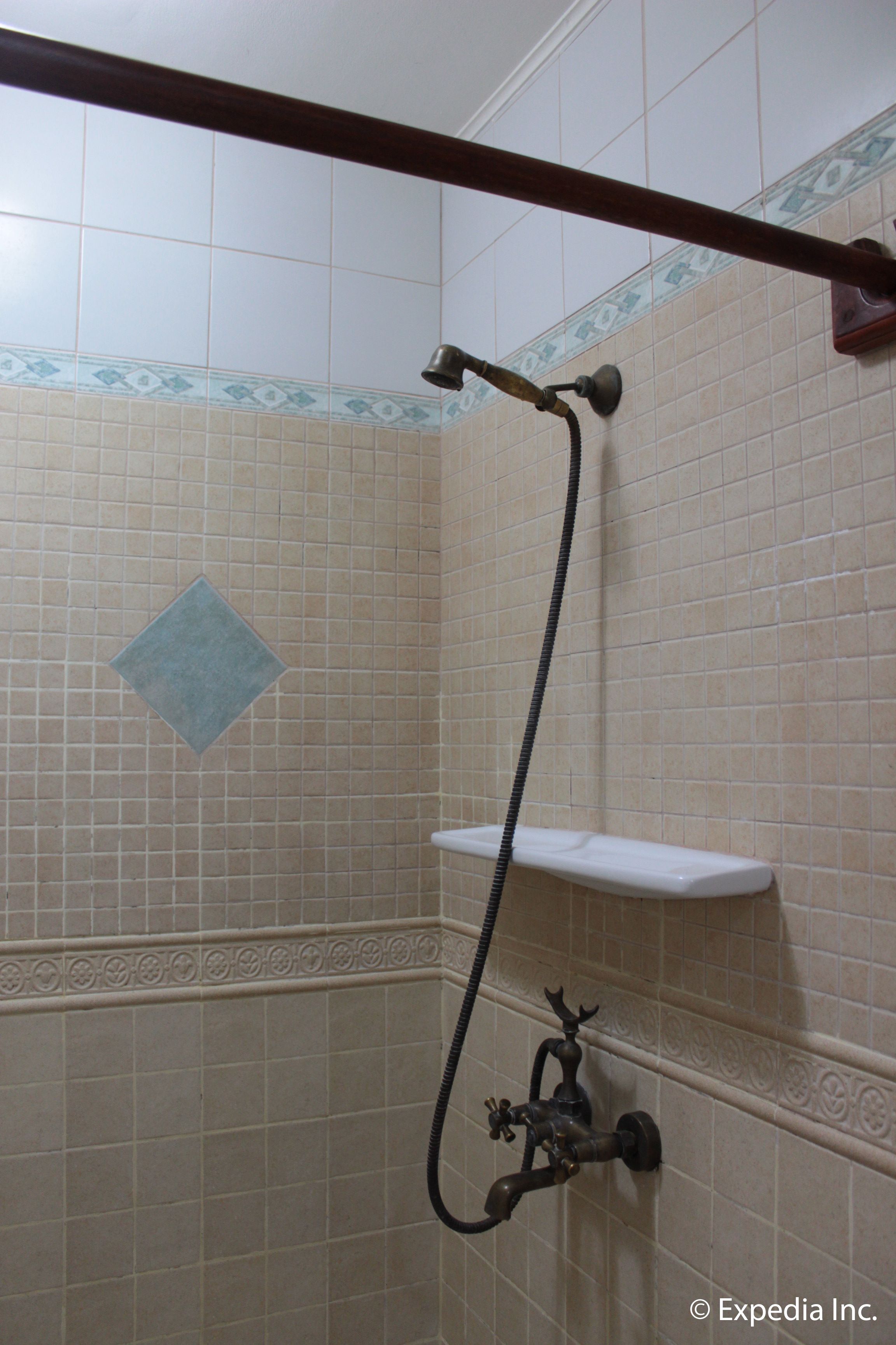 Ein Badezimmer mit Dusche, Handtuchhalter und einem dekorativen Fliesendesign.