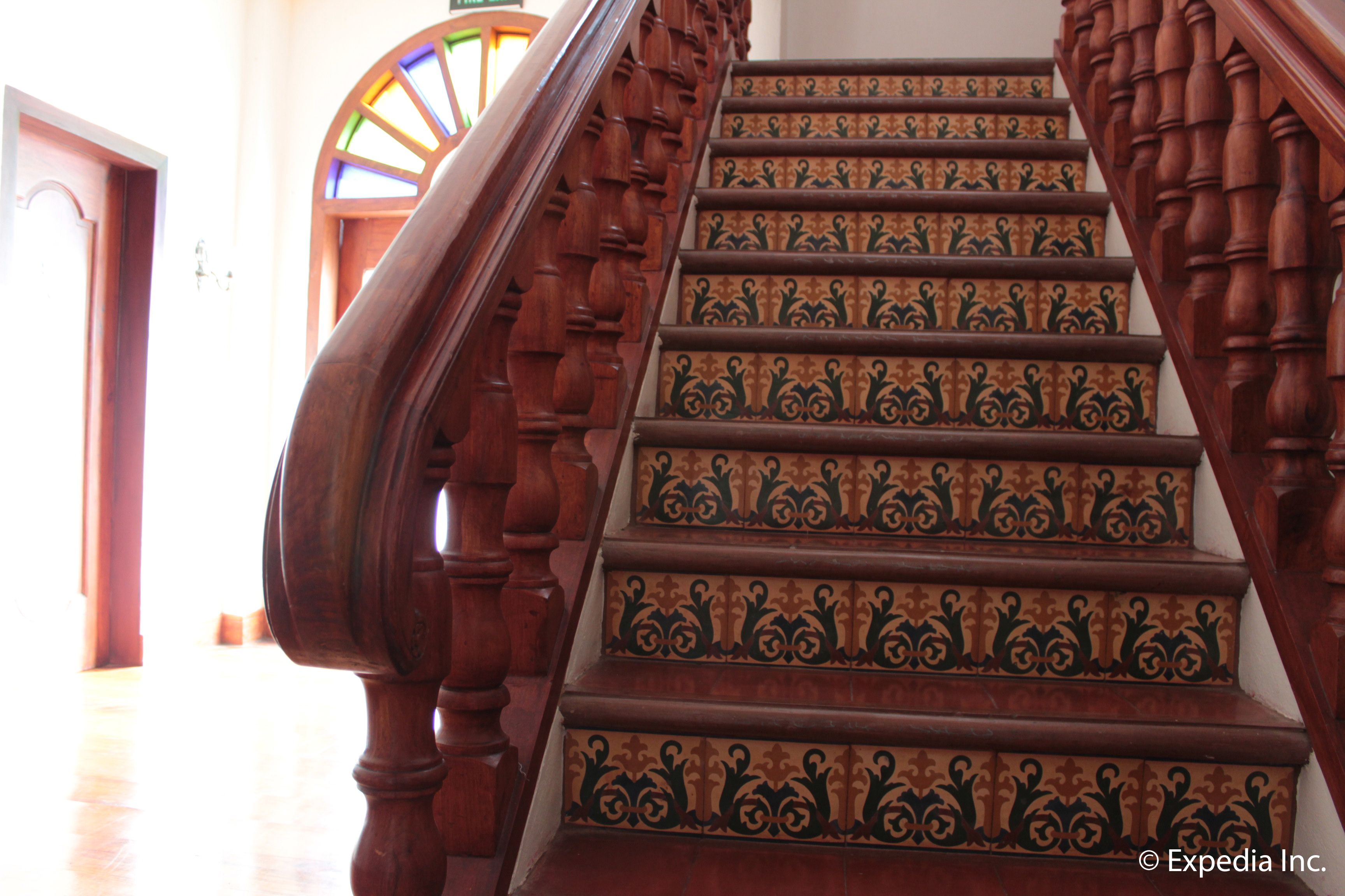 A wooden staircase with ornate balusters and patterned steps.