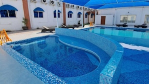 Una piscina con borde de azulejos y una cubierta azul.