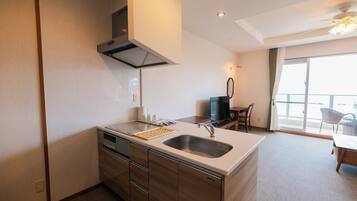 A modern kitchen with a built-in oven, a sink, and a dining area with a table and chairs.