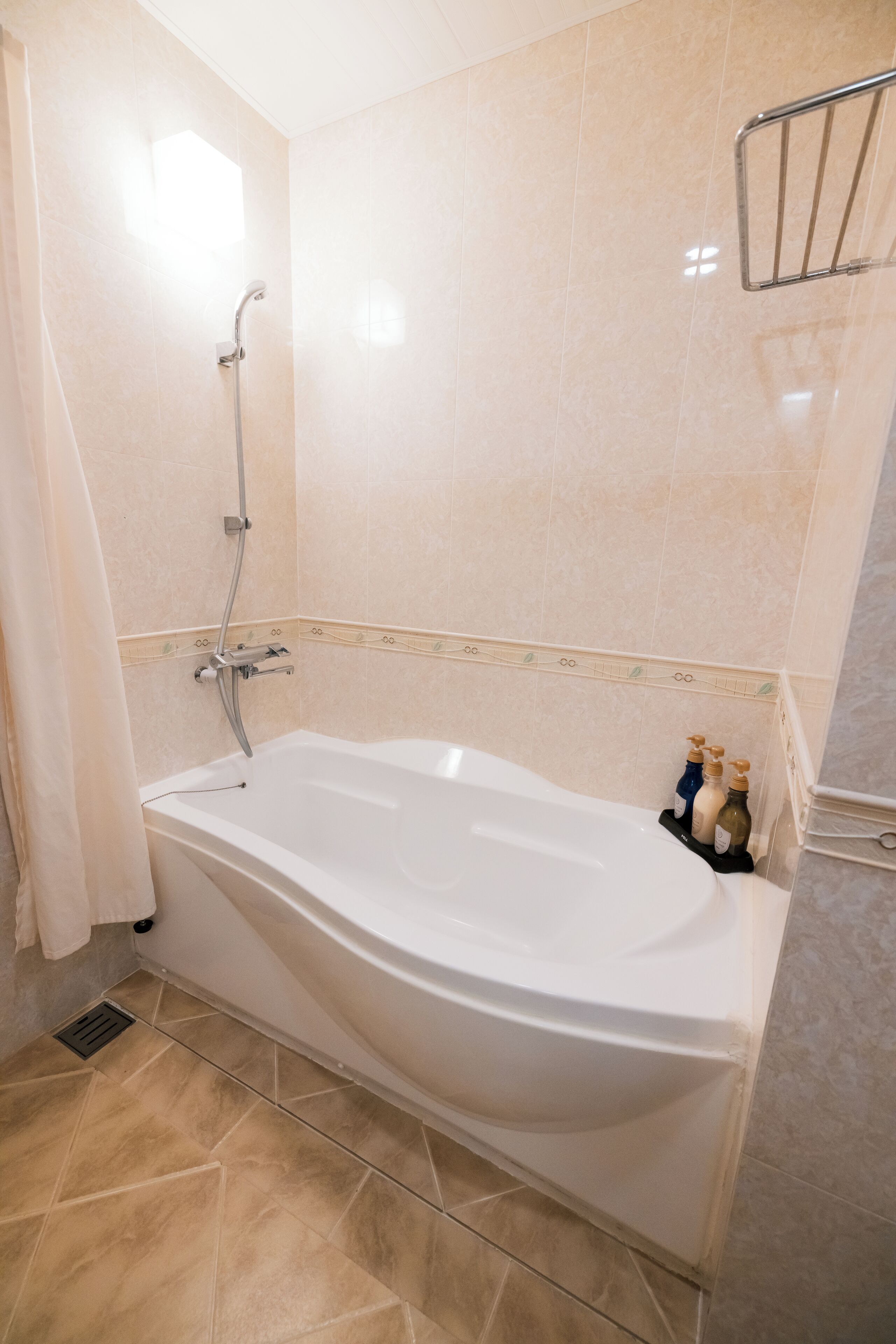 Ein Badezimmer mit Badewanne, Dusche und Handtuchhalter.