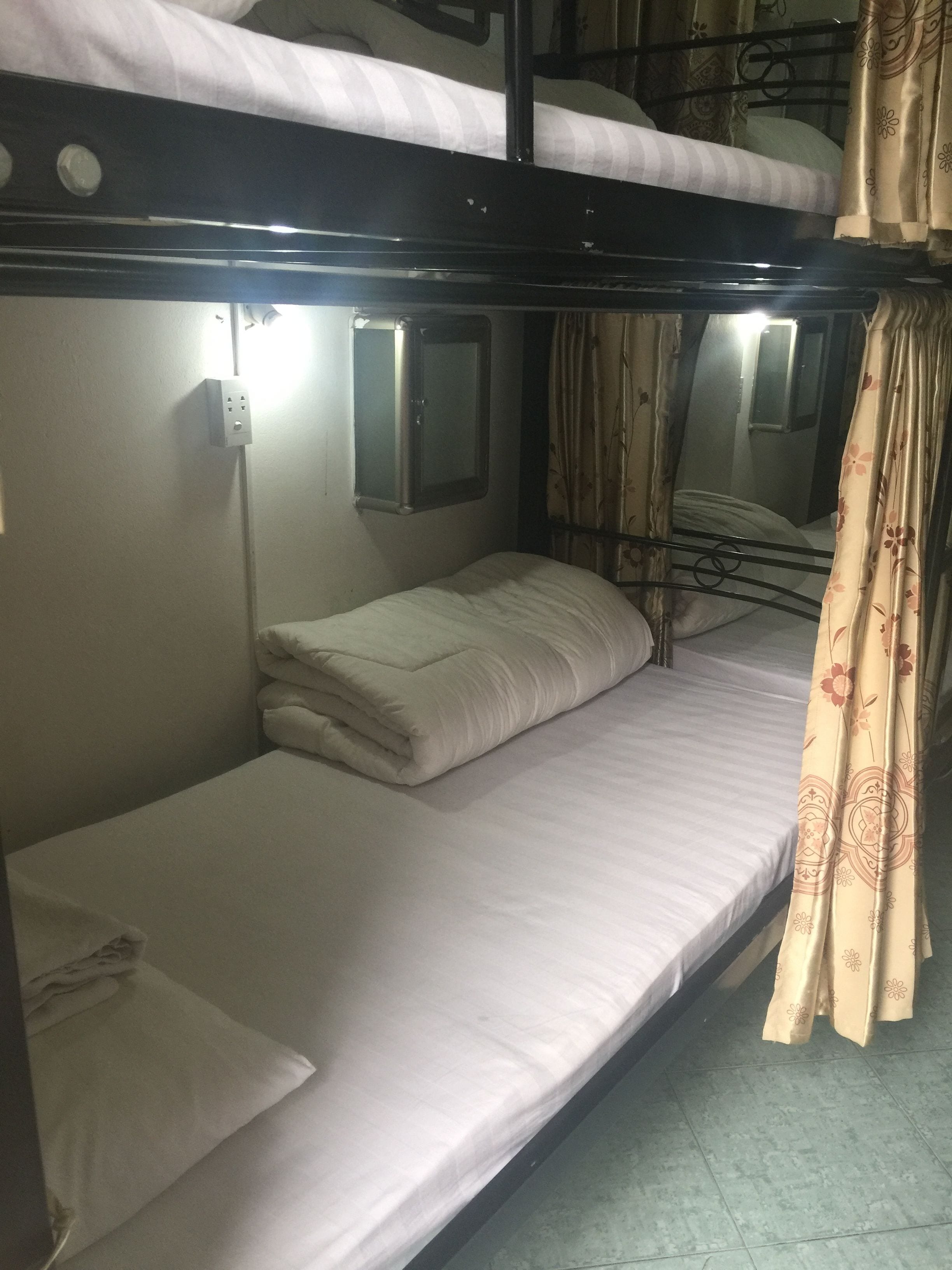 A bunk bed with a small window and a power outlet.