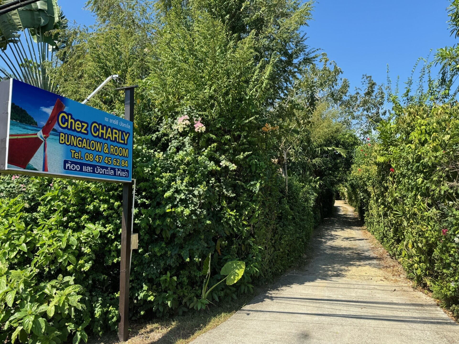 A sign for Chez Charley Bungalow & Room with contact information.