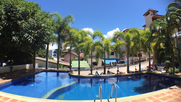 A swimming pool surrounded by palm trees and buildings. - Lemon House (Patong)
