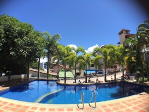 A swimming pool surrounded by palm trees and buildings.