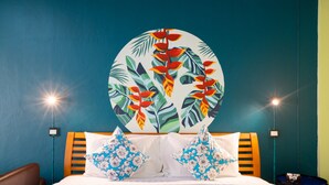 A hotel room with a bed, two pillows, a nightstand, and a wall painting. - Lemon House (Patong)