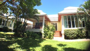 A two-story house with a covered porch and a small garden. - Lemon House (Patong)