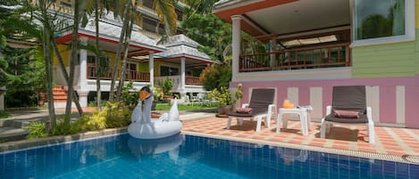 A swimming pool with lounge chairs and a swan float.