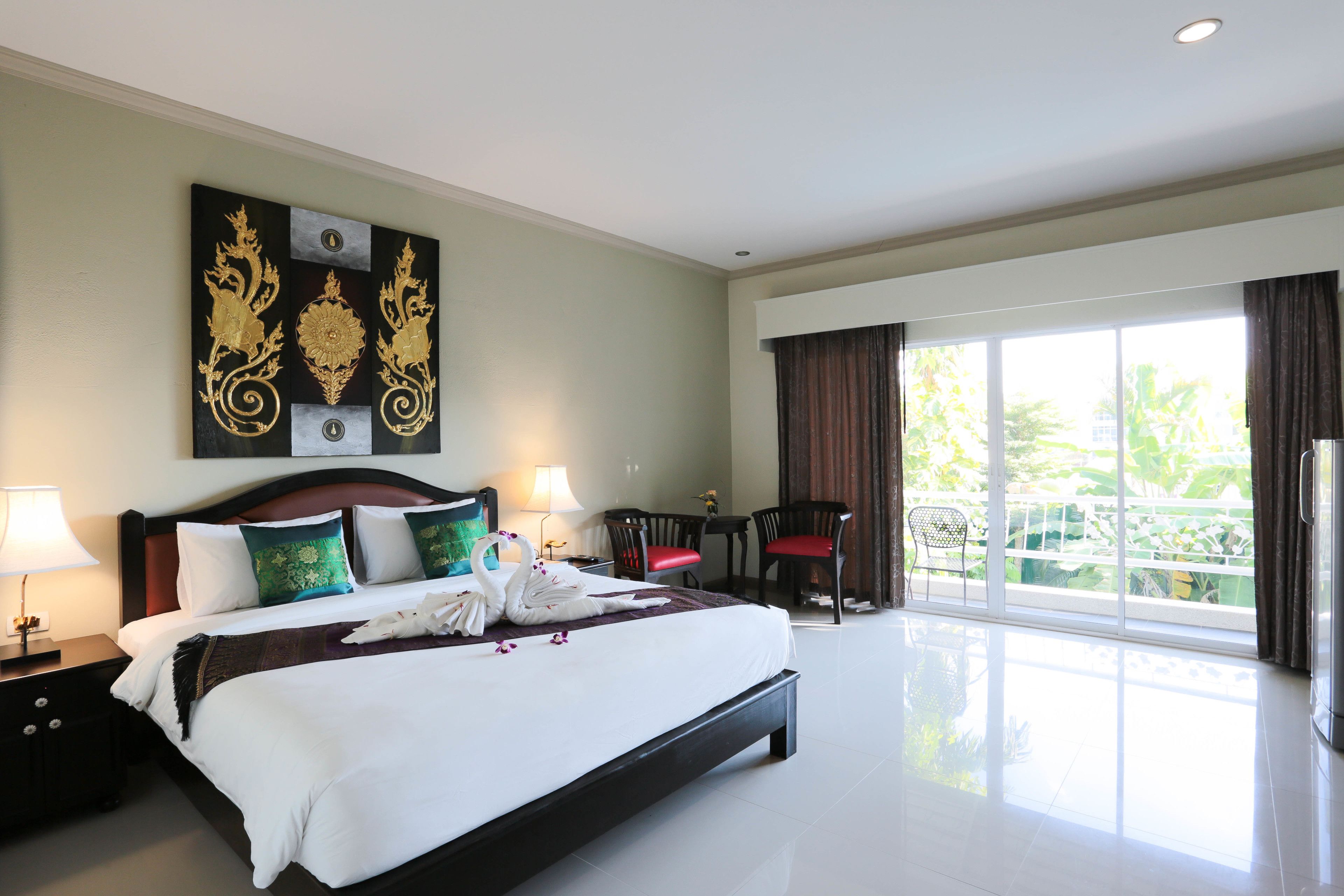 Une chambre d’hôtel avec un grand lit, un bureau, une chaise et un balcon avec vue.