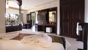 A hotel room with a large bed, a desk, a television, and a wardrobe. - Naka Resort (Kamala)