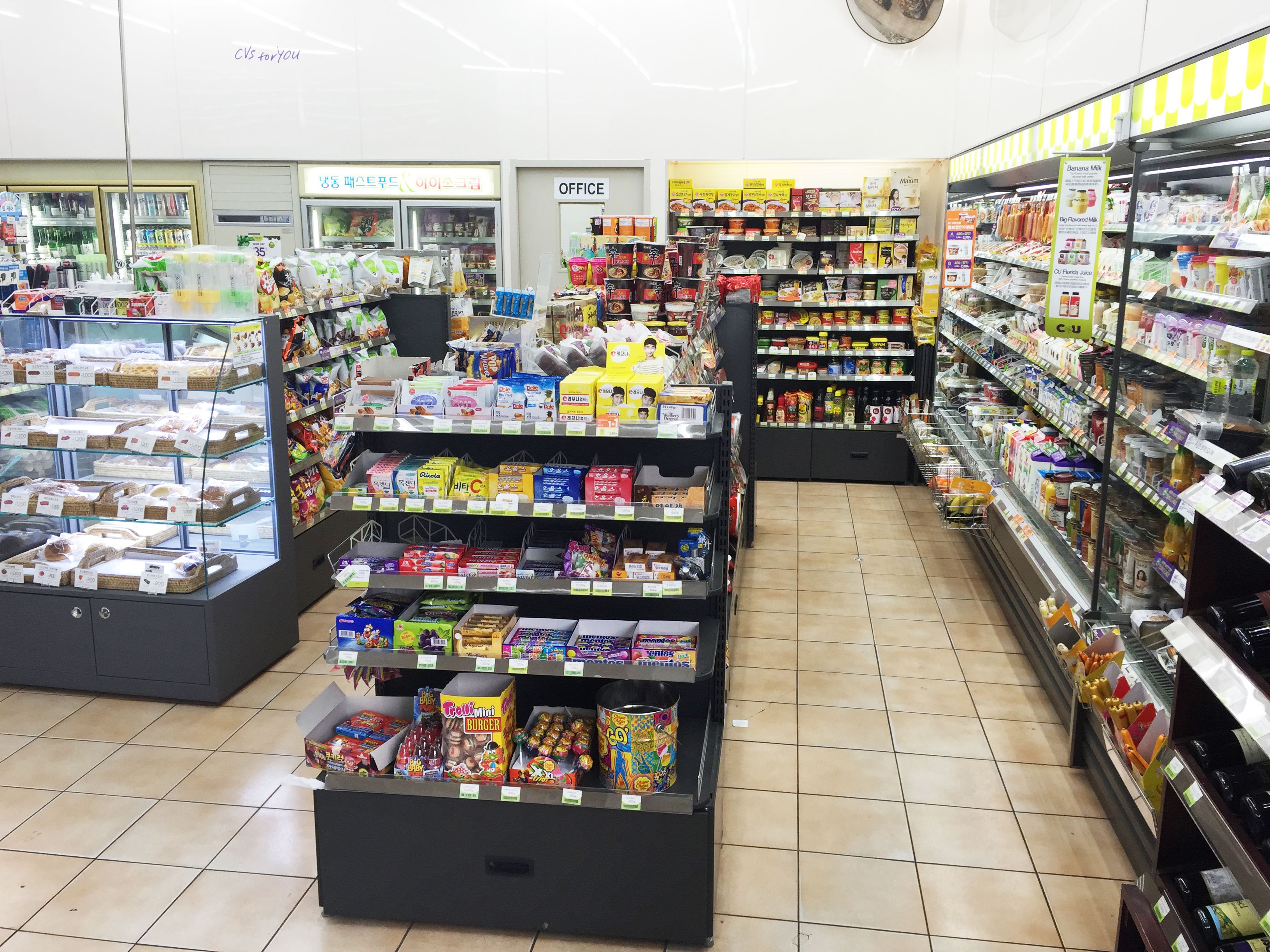 Un supermercado con varios pasillos repletos de snacks, bebidas y productos envasados.