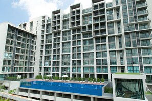 A modern multi-story building with a rooftop pool area and outdoor seating. - Sugar Palm Residence (Phuket)