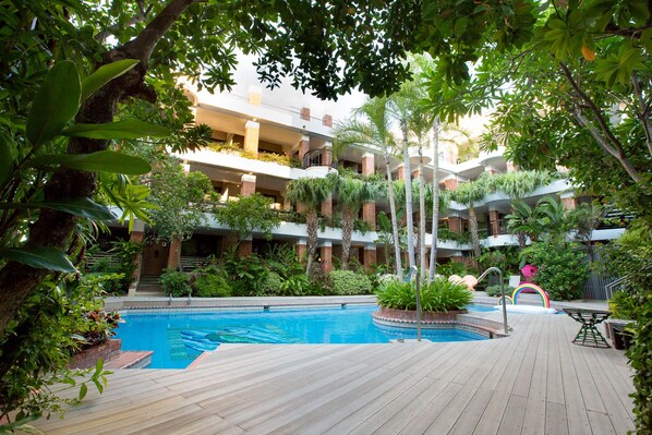 Een buitenzwembad en ligstoelen