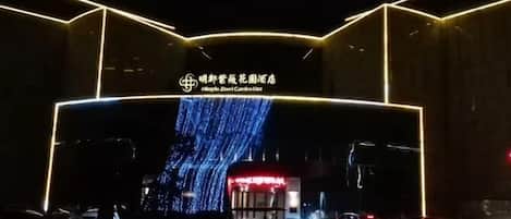 Fachada de edificio con señalización iluminada y una pantalla digital.