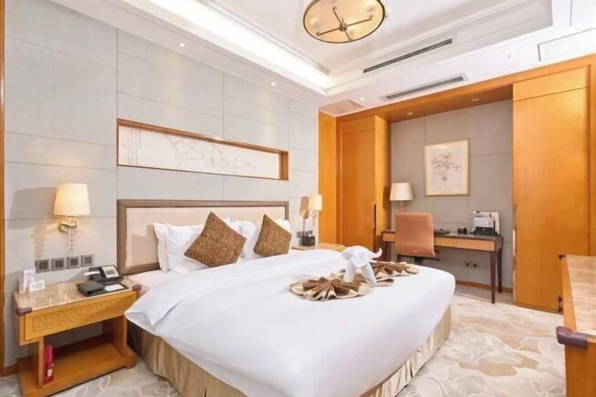 Une chambre d’hôtel avec un grand lit, un bureau et une chaise.